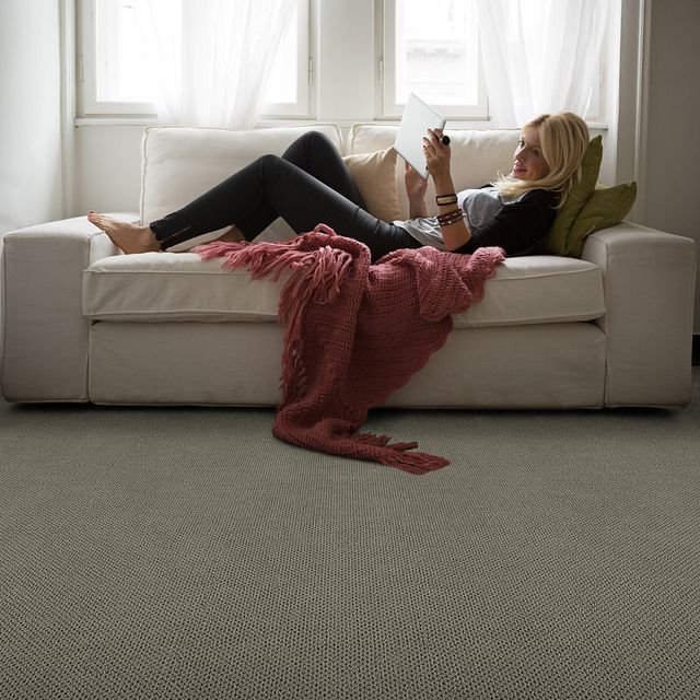 woman laying on sofa with salmon colored blanket